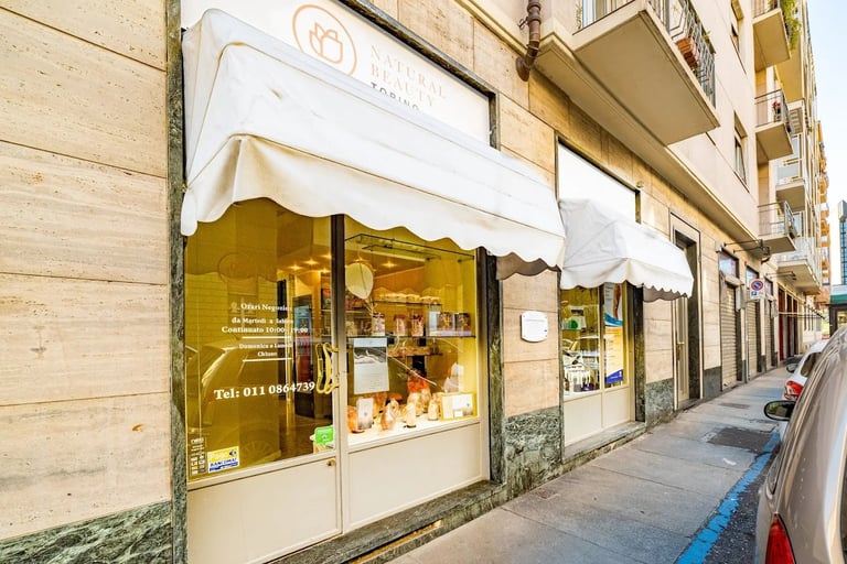 Street view of a small storefront with white awning in an urban residential building